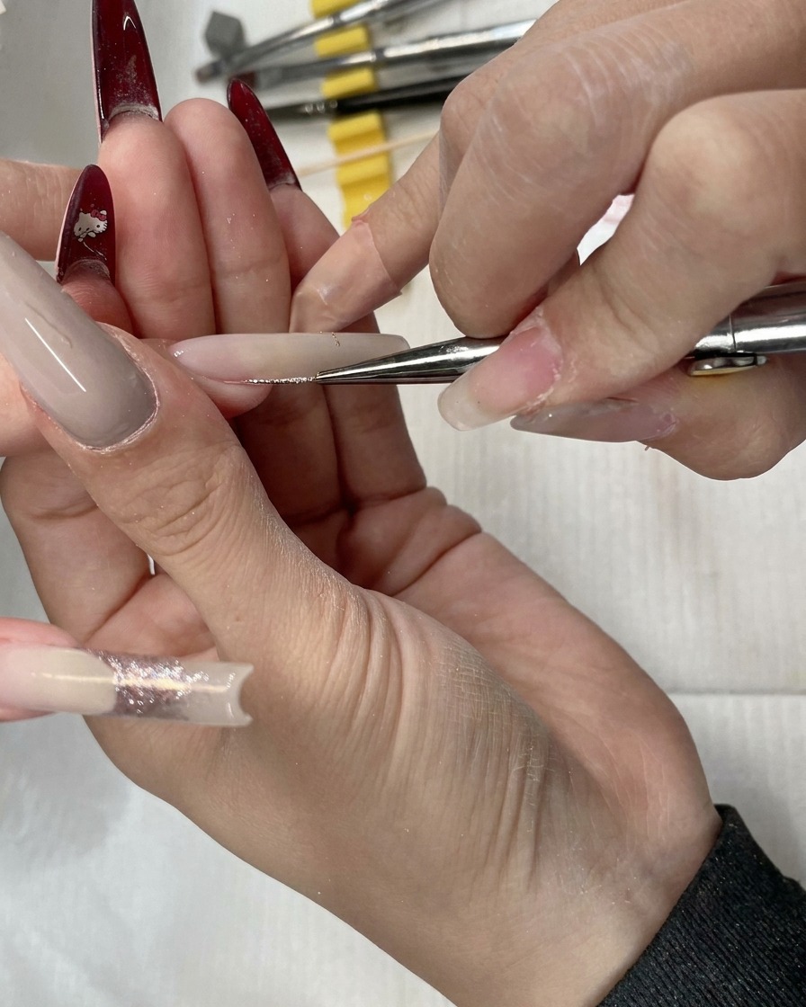 Gros plan dun liner appliquant les paillettes sur la largeur de longle.