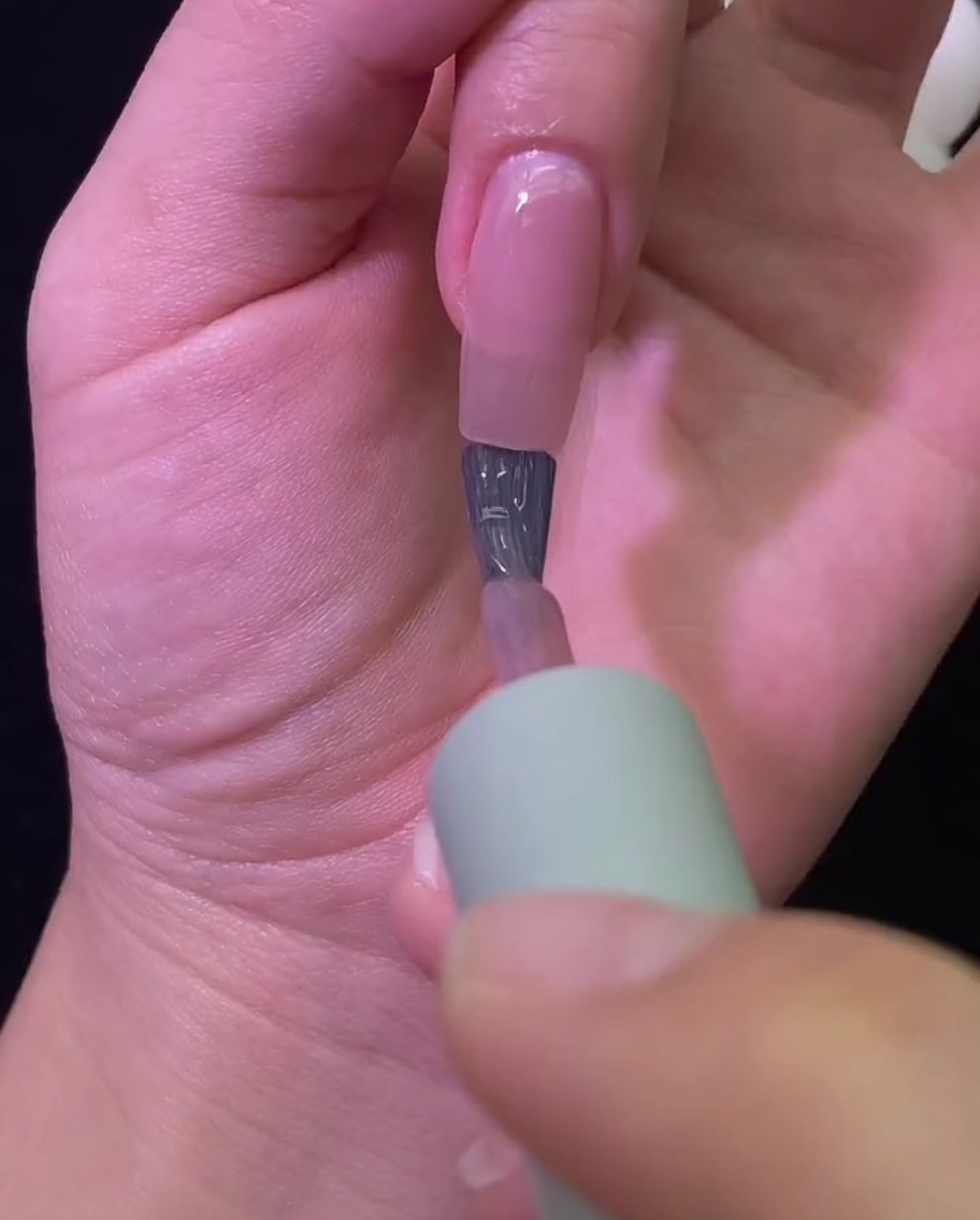 Une main reposant à lintérieur dune lampe à ongles UV/LED professionnelle pendant la polymérisation de la couleur.