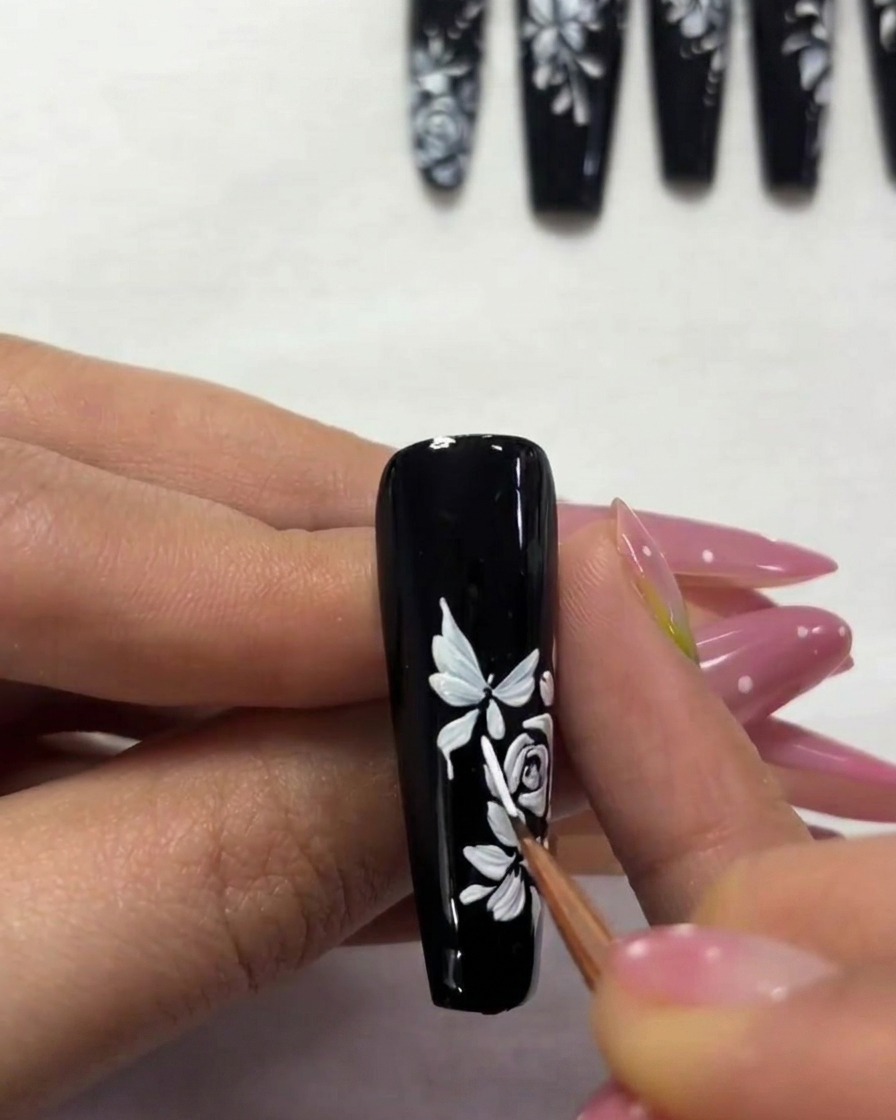Gros plan dun ongle montrant un papillon secondaire plus petit en cours de peinture vers le bord supérieur.