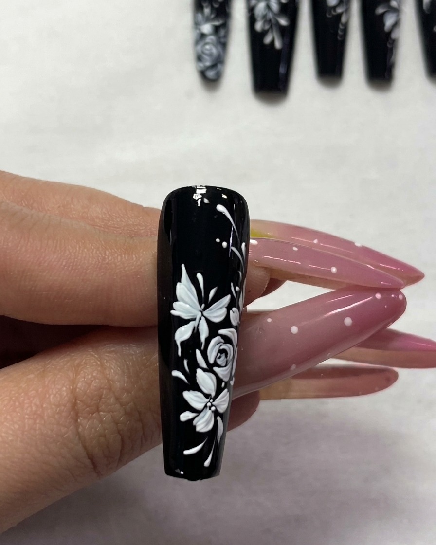 Un ongle manucuré étant placé sous une lampe UV pour la catalyse.