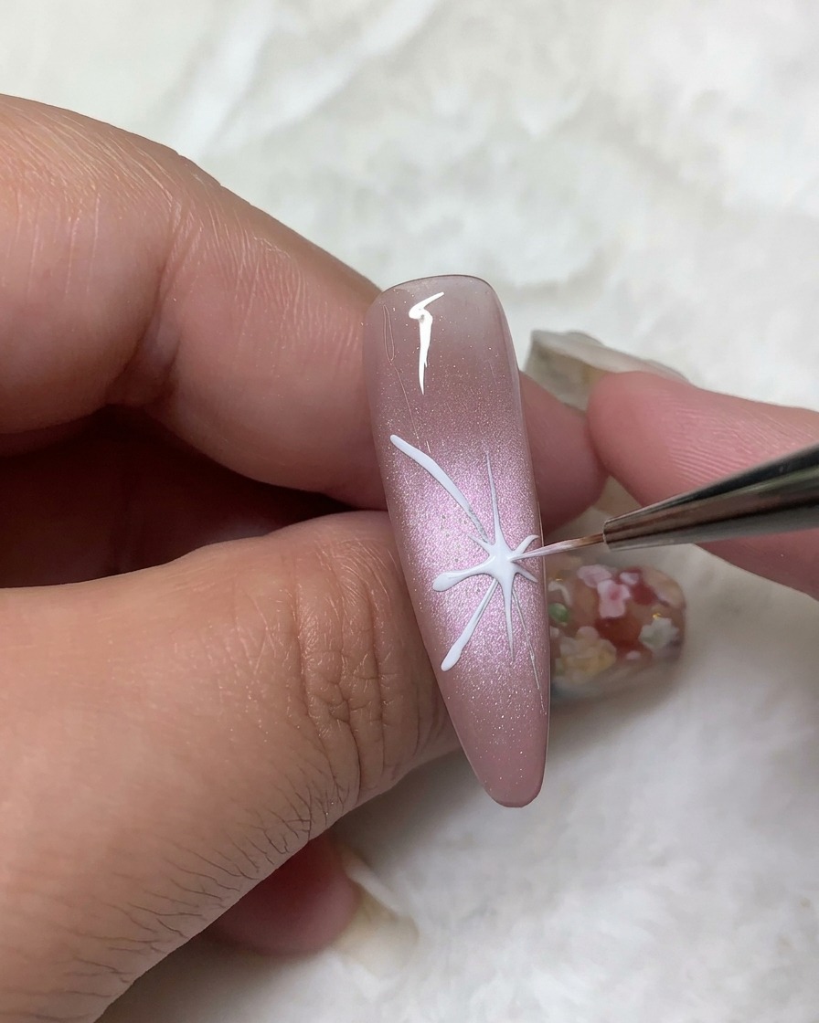 Un pinceau de précision remplissant les contours des ailes supérieures avec du vernis gel blanc opaque.