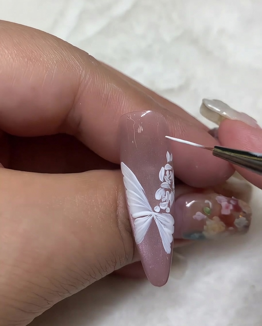 Gros plan avec un pinceau liner ajoutant de petits points blancs autour du design.