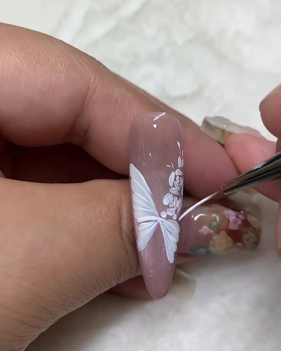 Gros plan sur le traçage des bords des ailes de papillon pour affiner les détails.