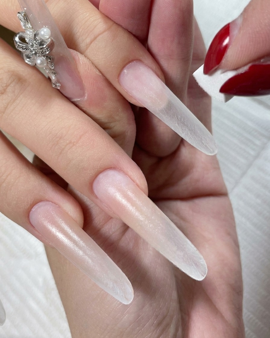 Une main reposant sous une lampe LED pendant que le vernis gel nude polymérise.
