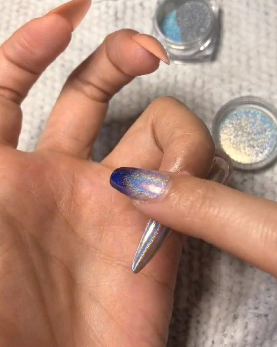 Gros plan montrant la poudre holographique étant estompée sur longle pour un look ombré.