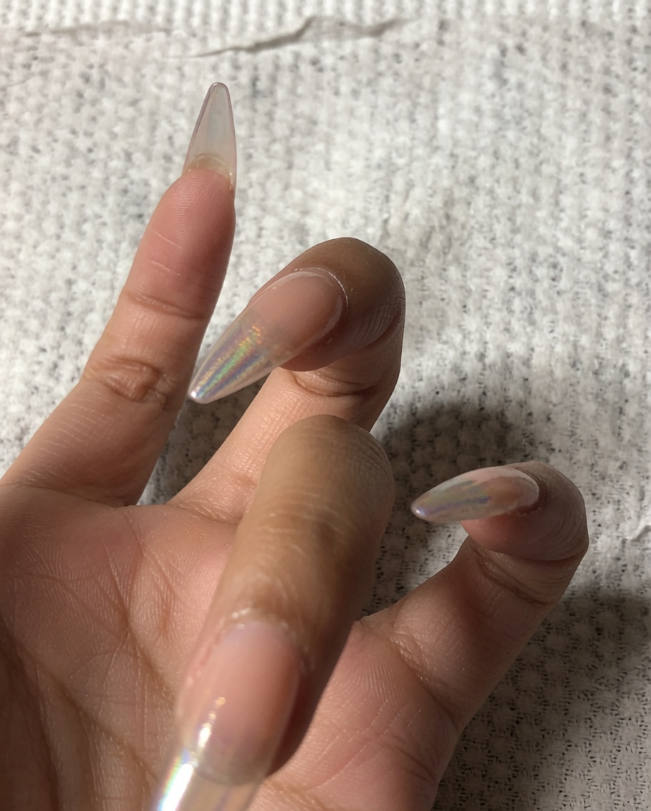 Une main utilisant un petit polissoir pour limer le bord avant dun ongle.