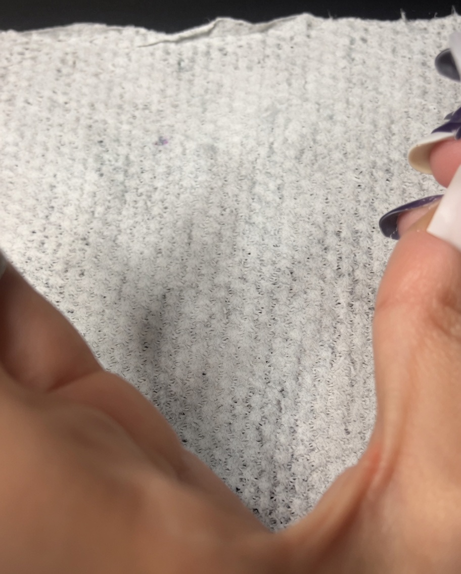 Une lingette non pelucheuse utilisée pour nettoyer la surface dun ongle manucuré.