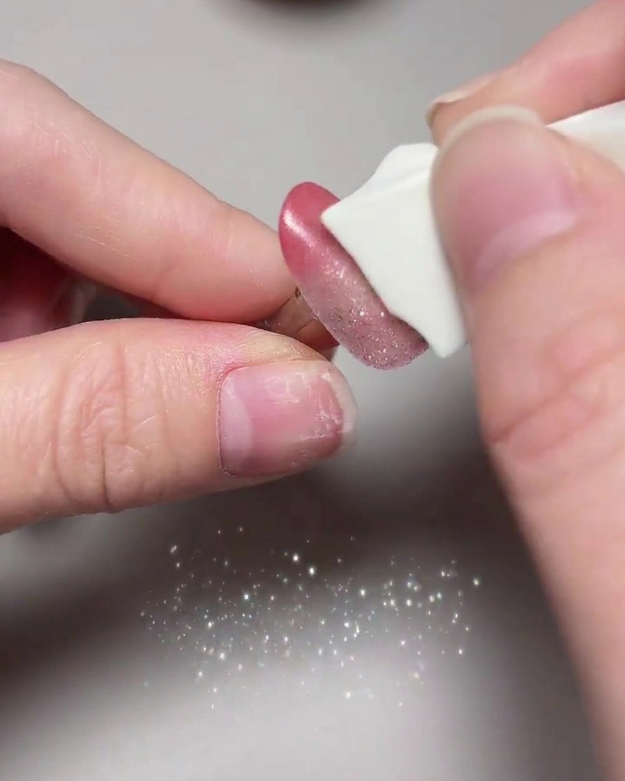 Gros plan des ongles cat eye terminés subissant leur catalysation finale à lintérieur dune lampe UV/LED.