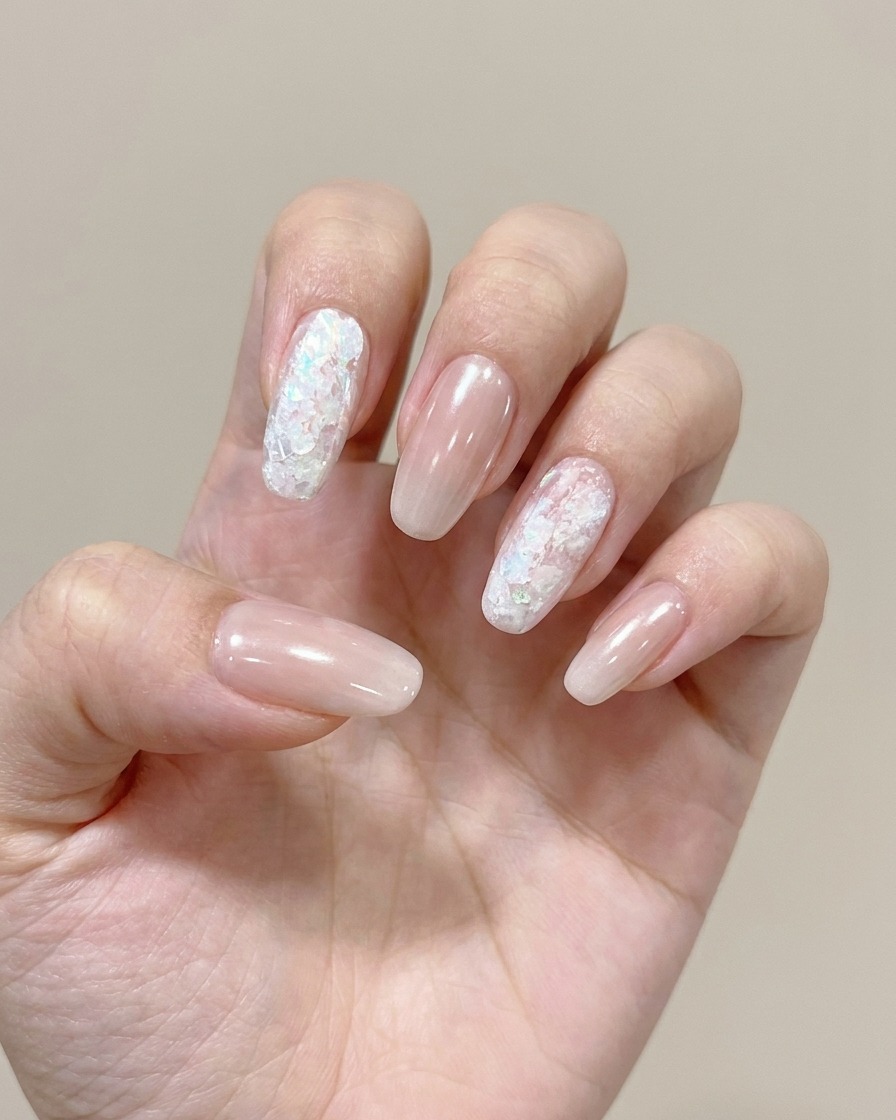 Un gros plan montrant une éponge appliquant un gel de couleur douce sur le bout dun ongle pour créer un effet ombré.