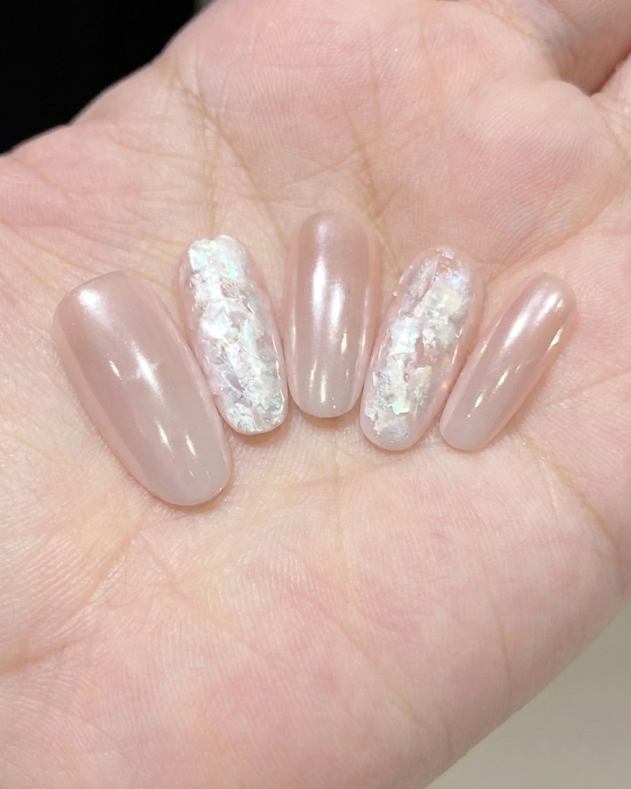 Un plan macro dun pinceau liner détaillant des motifs de nuages blancs sur la surface dun ongle.