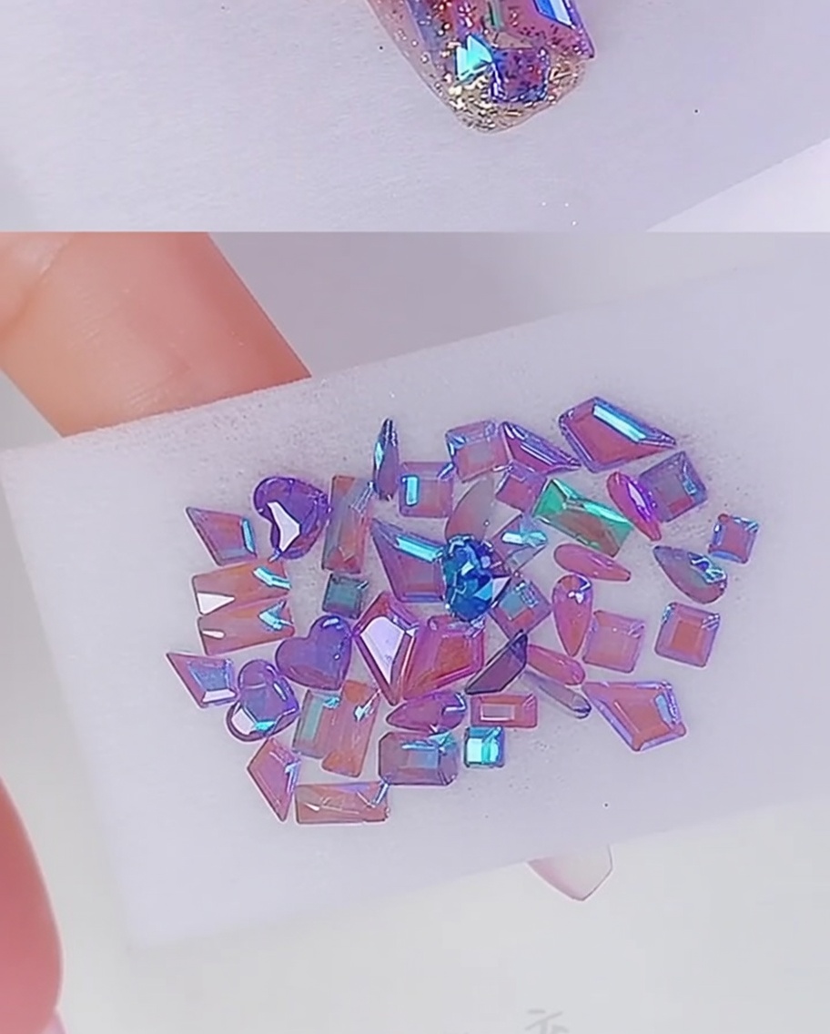 De petits points de colle transparente appliqués sur la plaque de longle pour ancrer les décorations en strass.