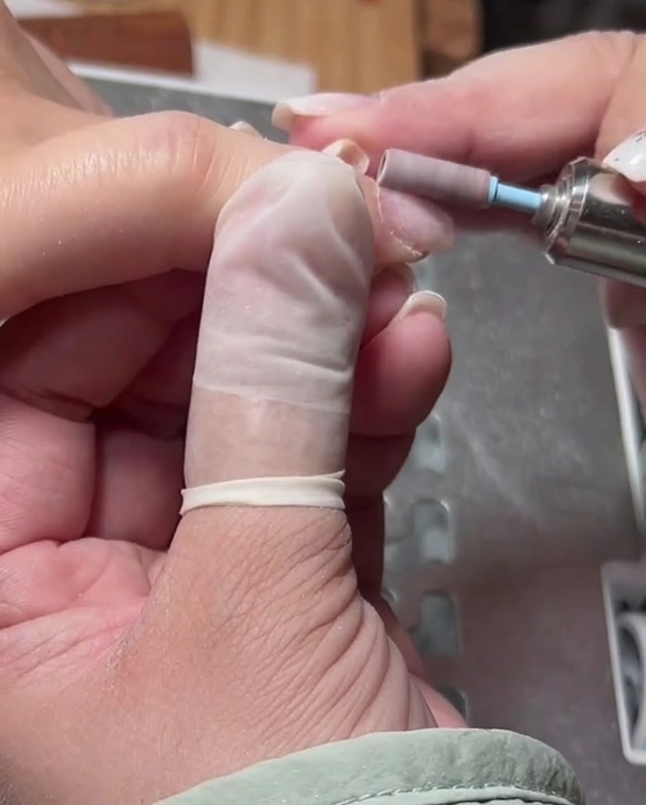 Gros plan dun embout de ponceuse cylindrique utilisé pour lisser la peau autour de la cuticule.