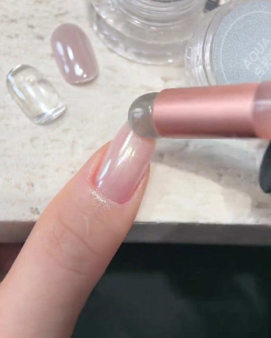 Un applicateur éponge déposant la poudre chrome blanche AQUA sur une surface dongle lisse et brillante.