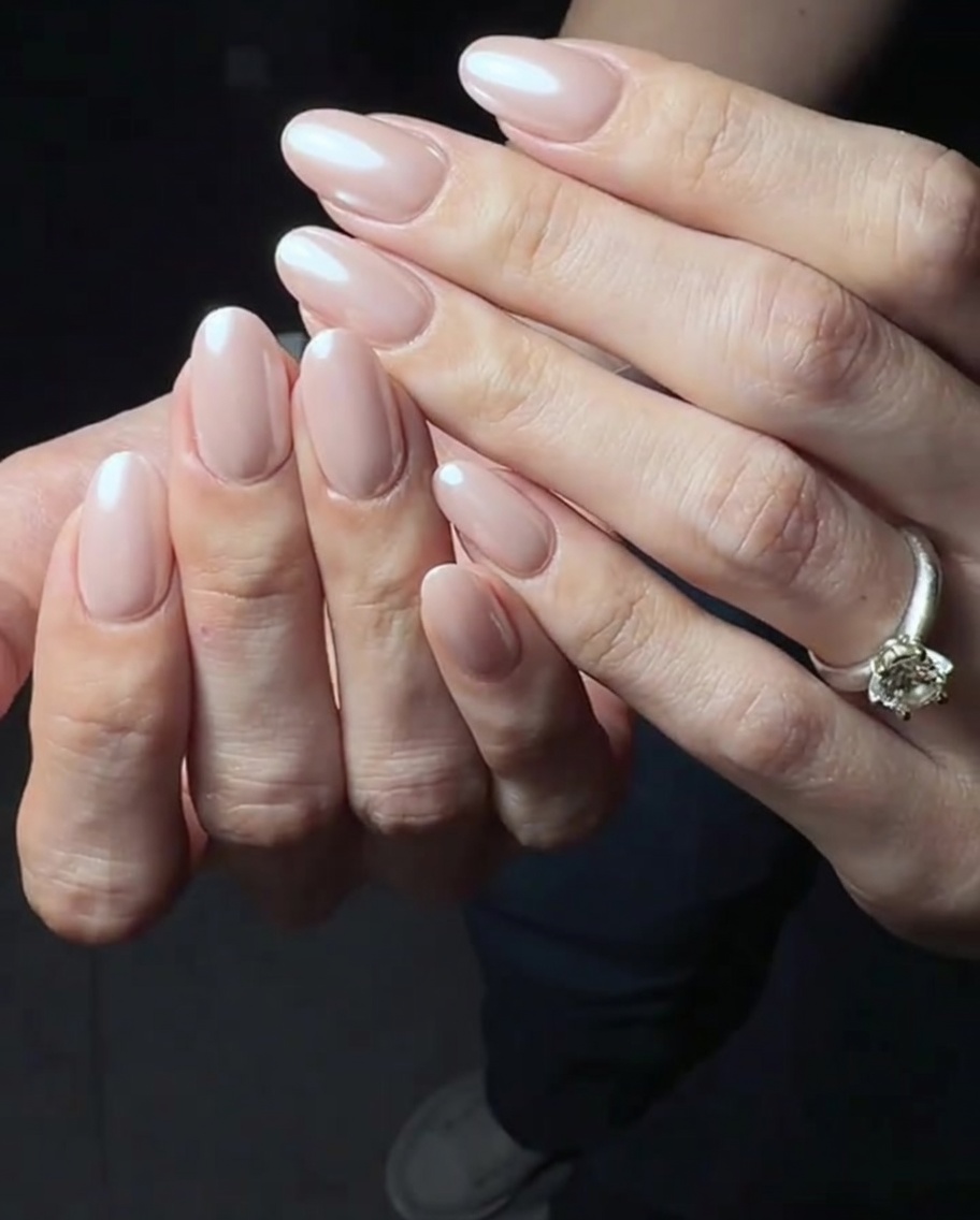 Une fine couche brillante de finition en train dêtre appliquée sur la base en gel rose.