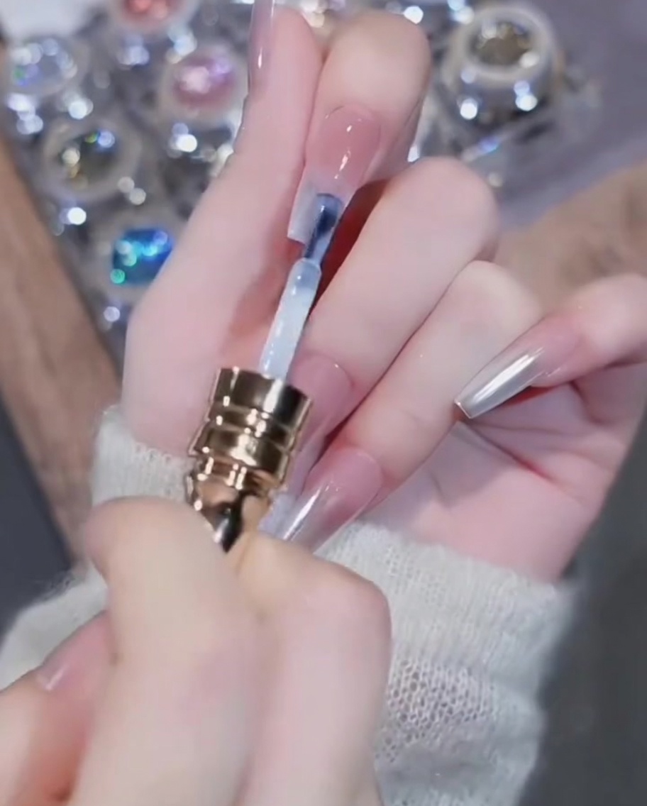 Pinceau appliquant du vernis gel blanc sur le bord libre de longle.