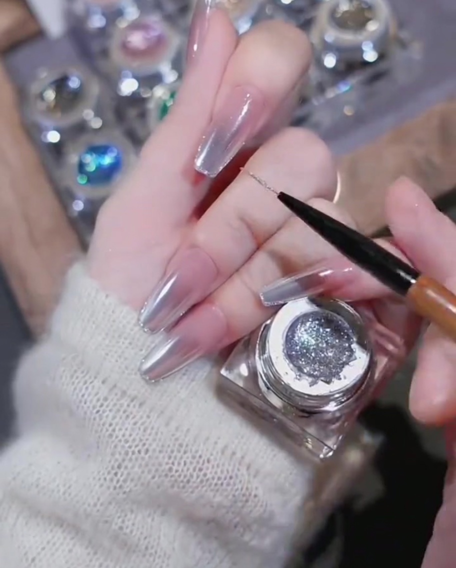 Gros plan sur un charm cœur en strass posé sur des lignes de gel brillant.
