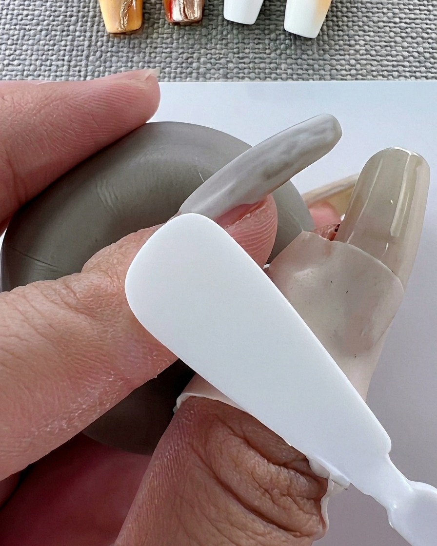 Un pinceau appliquant un vernis gel blanc lisse sur la surface de longle.
