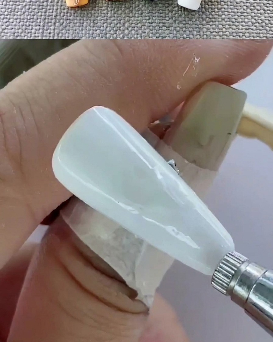 Vue rapprochée dune main dans une lampe UV en train de catalyser les ongles.