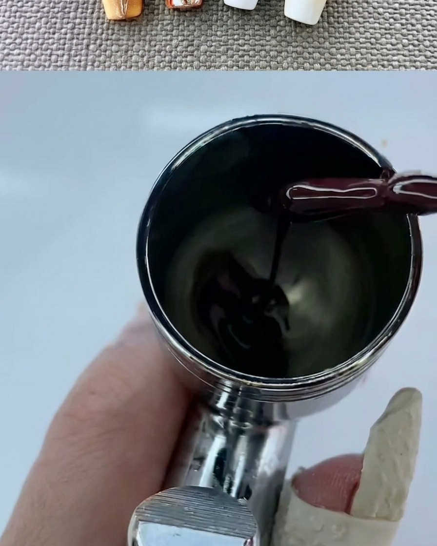 Un aérographe créant un dégradé chaud et doux sur un ongle à base blanche.