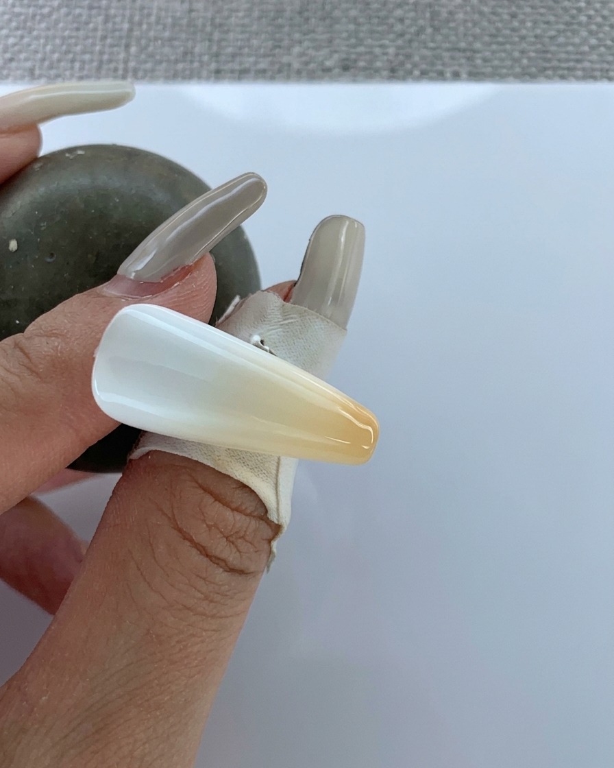 Un pinceau appliquant un top coat transparent sur le dégradé réalisé à laérographe.