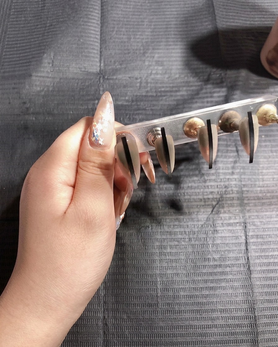 Les ongles catalysant sous la lampe UV pour la seconde fois.