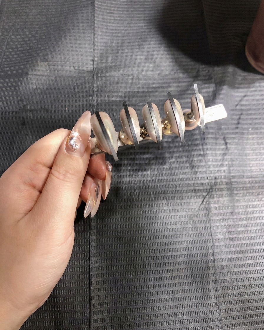 Pistolet à aérographe appliquant la première couche de gel blanc sur un deuxième set dongles.