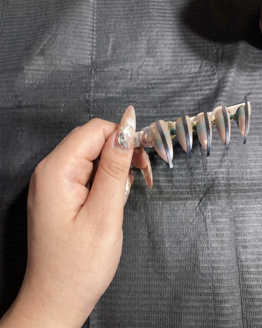 Support avec faux ongles placés à lintérieur dune lampe UV pour catalyser.