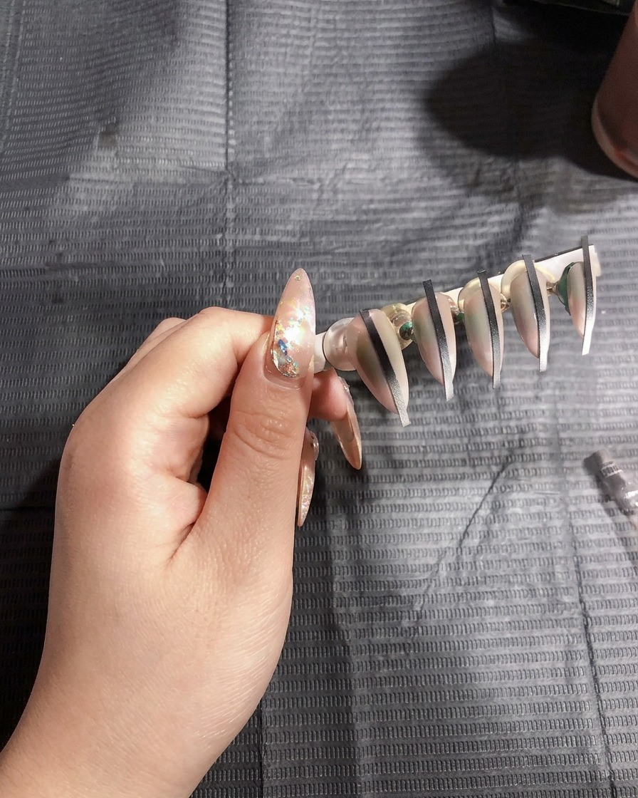Faux ongles sur support catalysant sous la lumière vive dune lampe UV.
