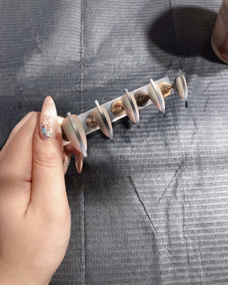 Faux ongles catalysant sous une lampe UV, signalant la fin de lapplication de couleur.