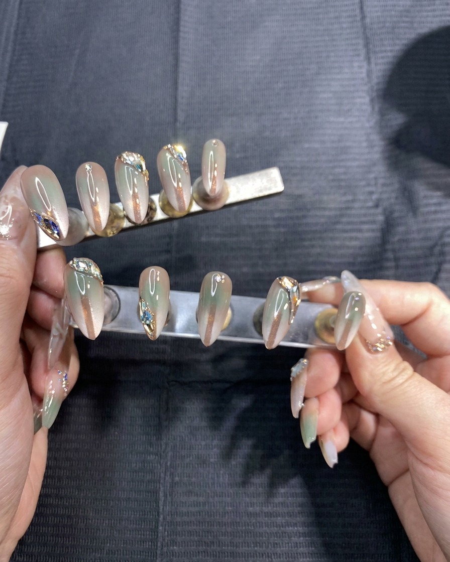 Mains retirant délicatement des stickers pochoirs dun set de faux ongles peints en dégradé.