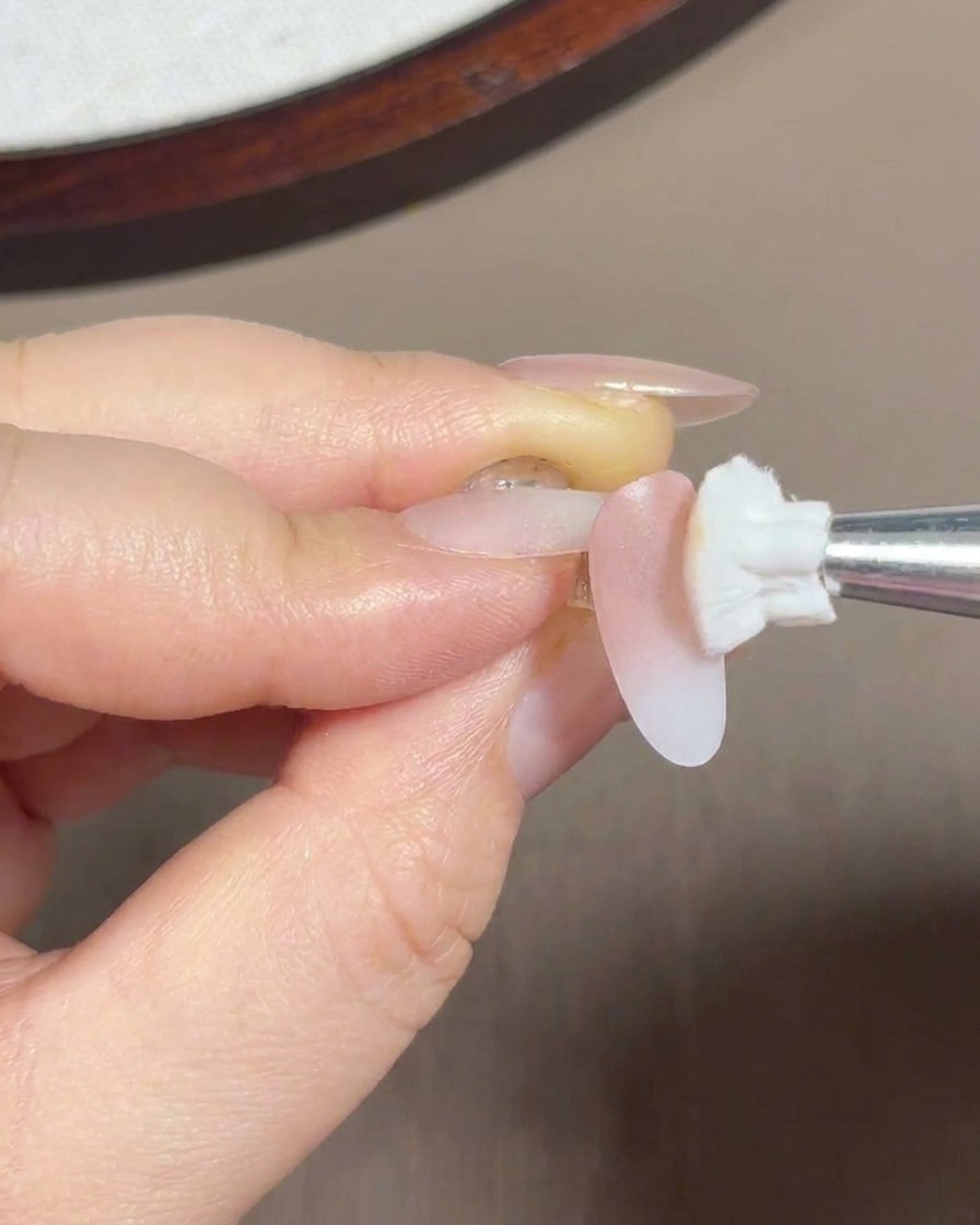Un embout éponge estompant du gel rose sur la moitié arrière et la zone de la cuticule de longle.