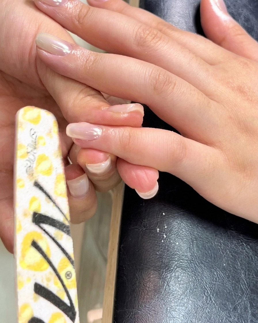 Un pinceau fin de type liner étalant uniformément le gel de construction vers la cuticule et les parois latérales de longle.