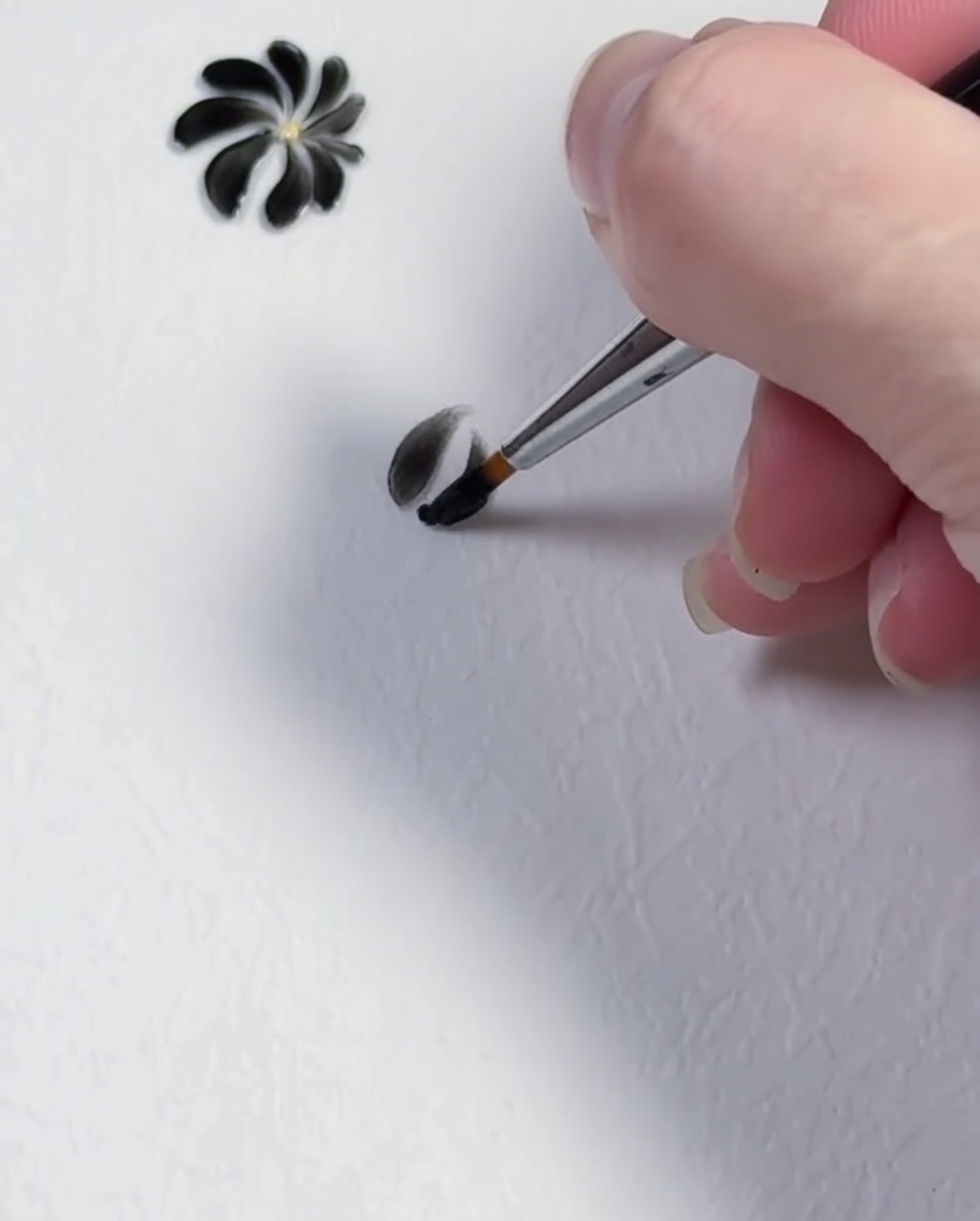 Un coup de pinceau formant le troisième pétale noir dun design de marguerite.