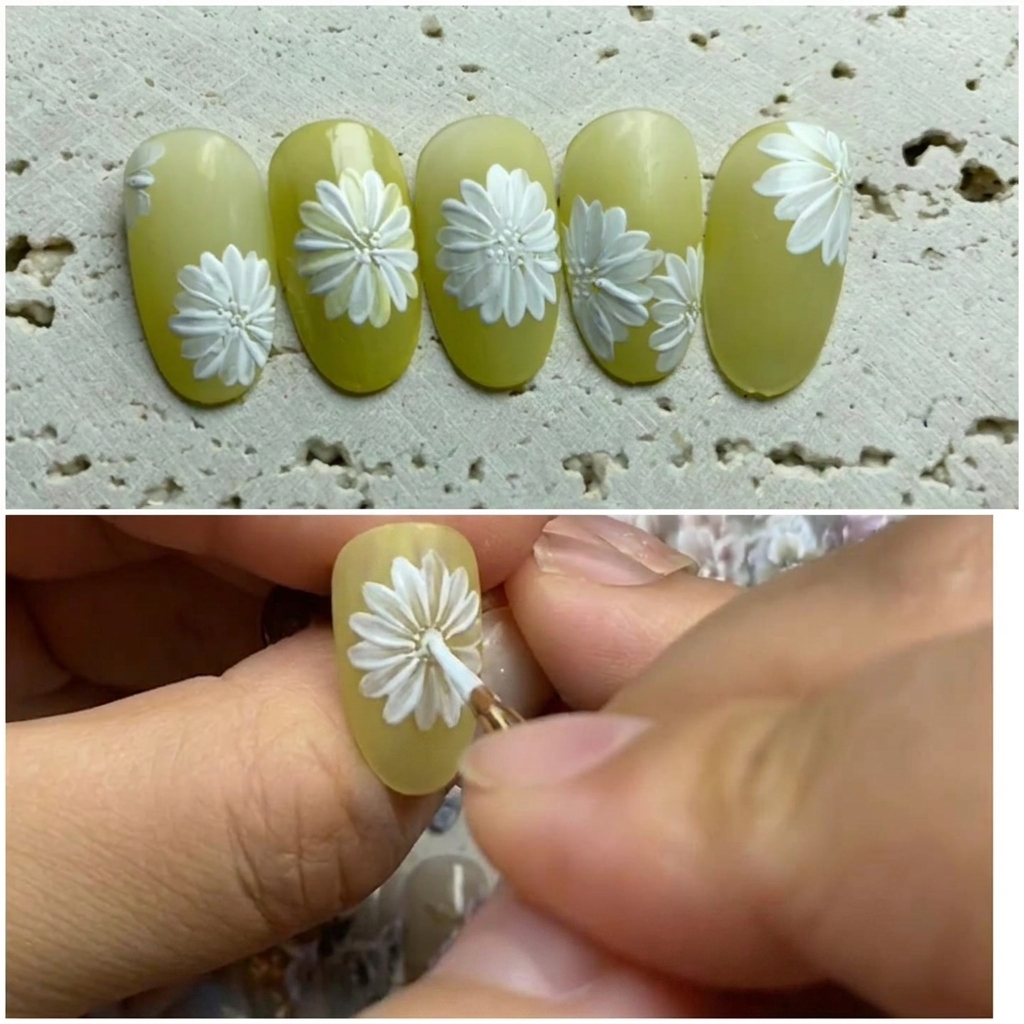 Gros plan dun nail art où un pinceau ajoute des pétales blancs entre ceux existants pour étoffer la marguerite.