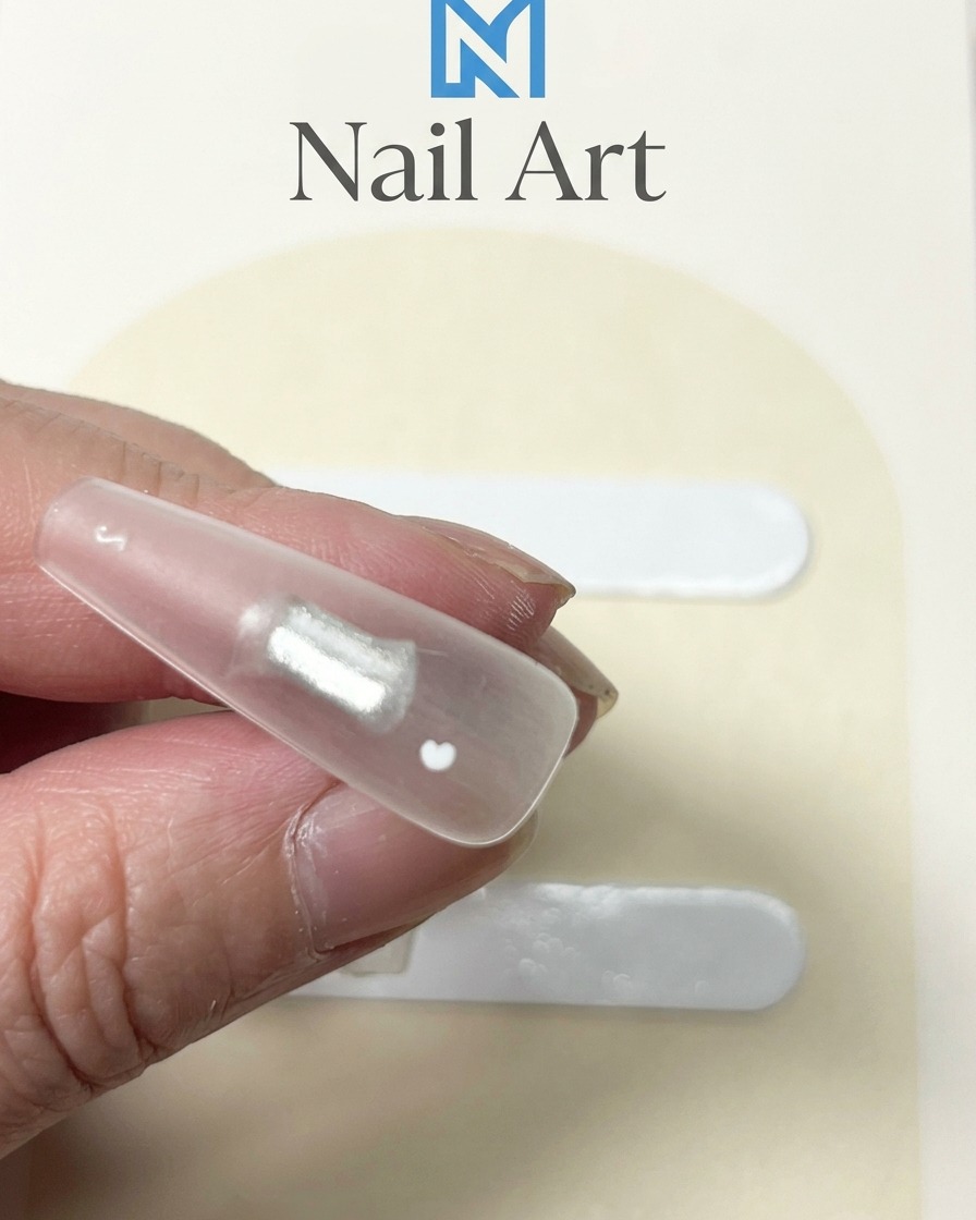 Gros plan sur un ongle transparent avec un point de gel blanc épais appliqué au centre.