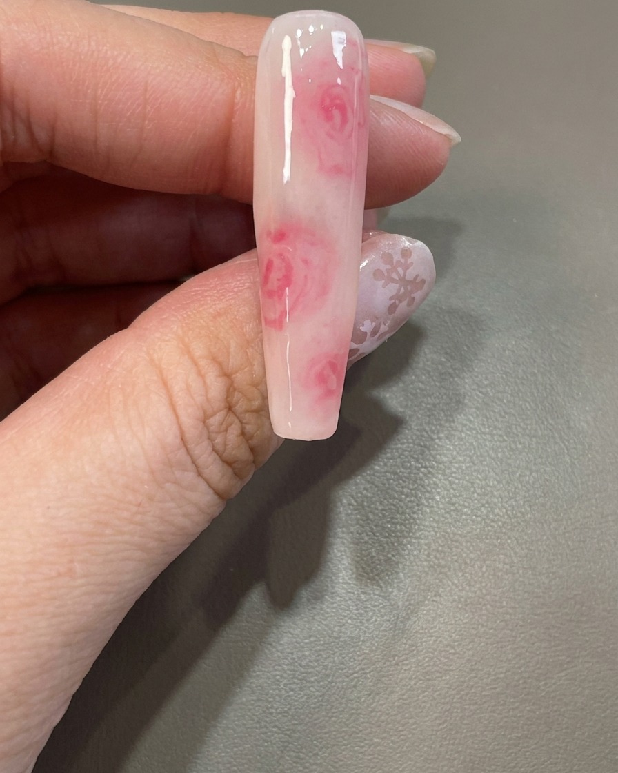 Un pinceau réappliquant une couche de blooming gel transparent sur un design dongle existant.