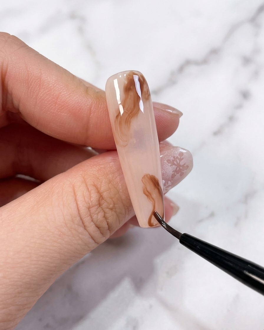 Deux petits points de gel marron placés sur la surface dun ongle avec une base non catalysée.