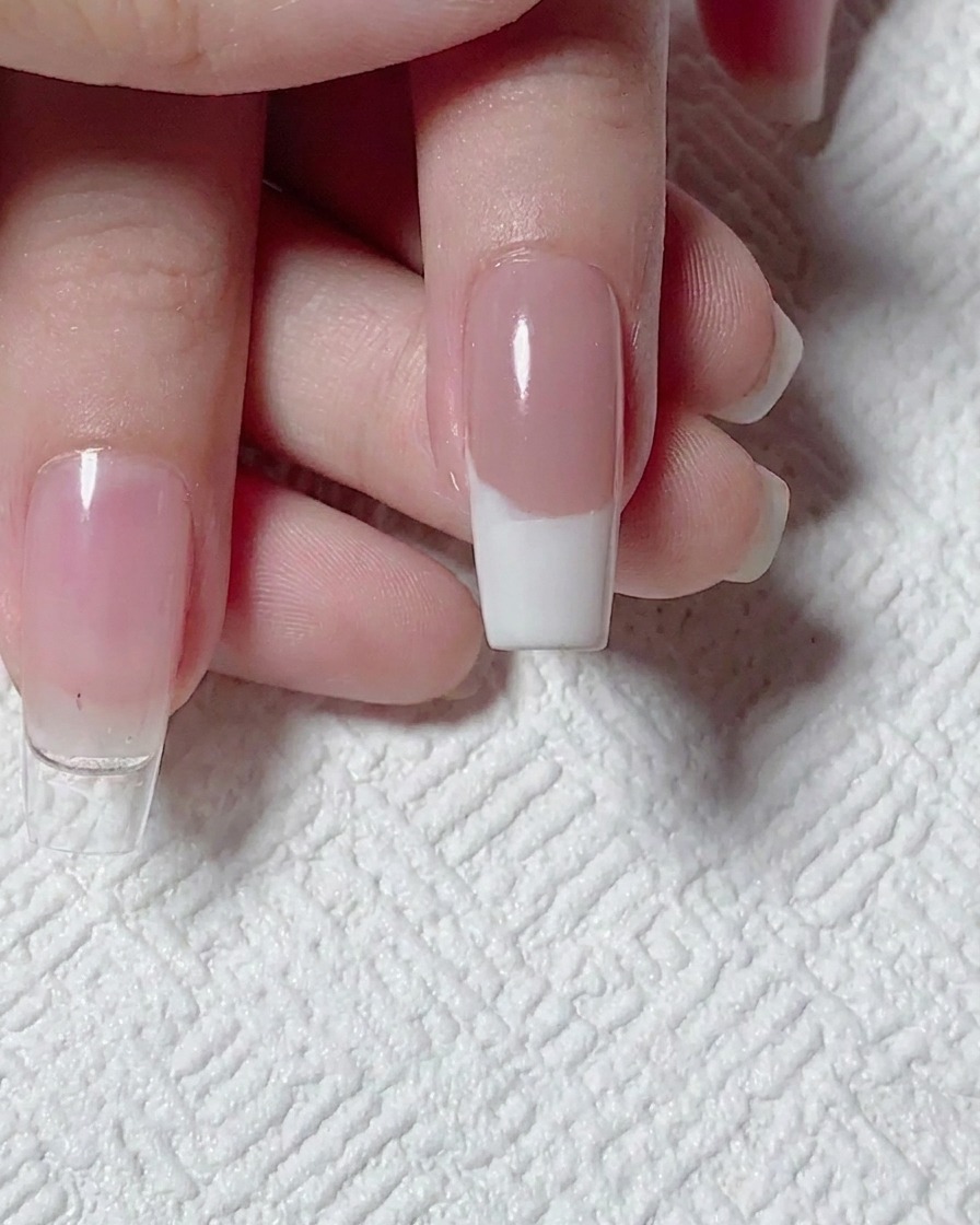 Vue de dessus dune French manucure blanche terminée sur base nude, prête pour le nail art.