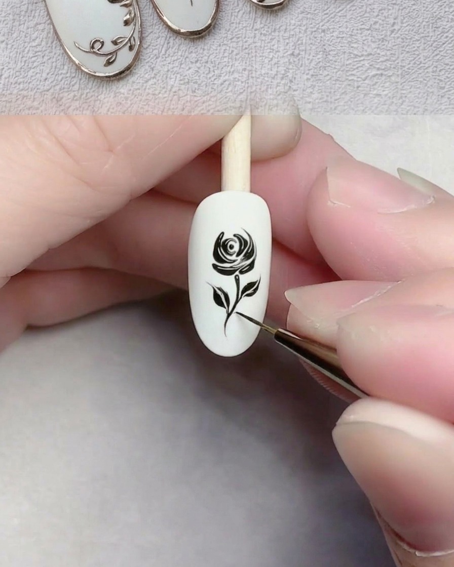 Gros plan dun pinceau liner dessinant une fine ligne noire représentant une tige sur un ongle blanc.