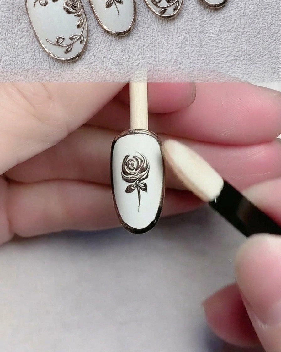 Un applicateur éponge polissant la poudre chrome dorée sur un design dongle détaillé.