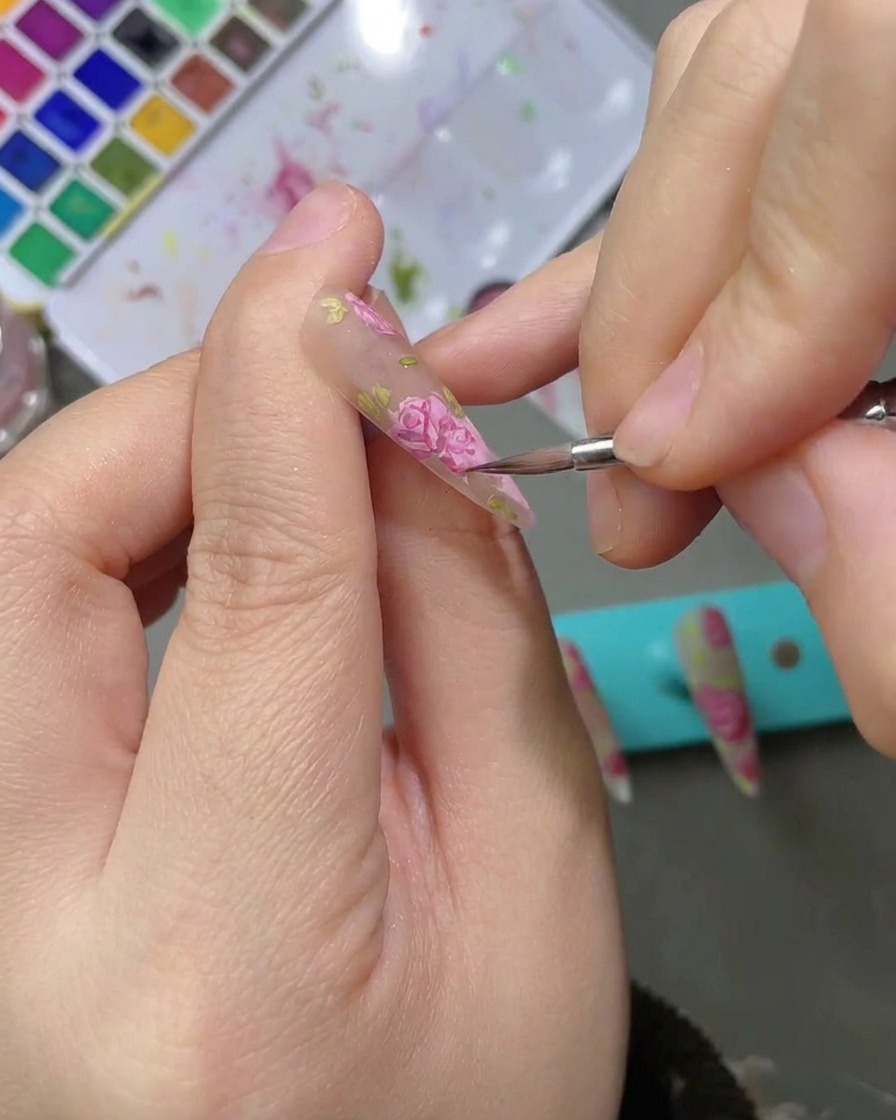 Lapplication dun top coat mat sur un design dongle fini et détaillé avec une rose à laquarelle.