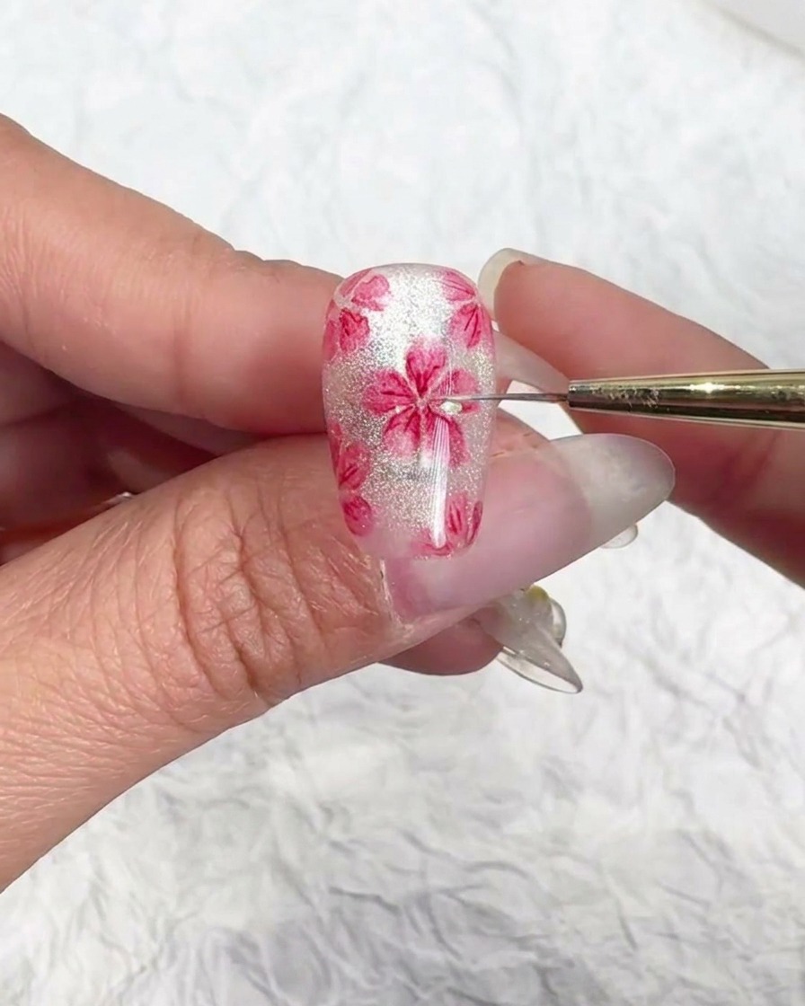 Application de gel de renforcement sur un nail art cerisier fini.