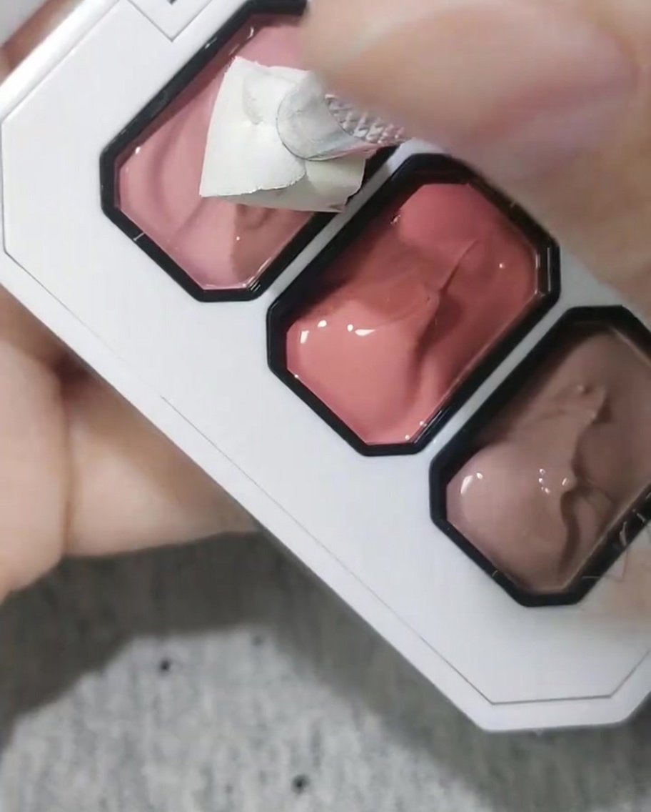 Une éponge cosmétique utilisée pour appliquer du gel rose sur le bout de longle.