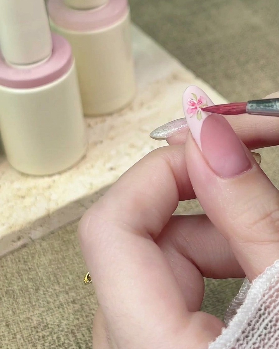 Un pinceau de détail ajoute plus de pétales à laquarelle pour compléter le design floral.