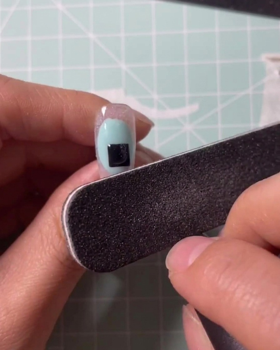Application dun gel transparent sur une capsule avec un pinceau.