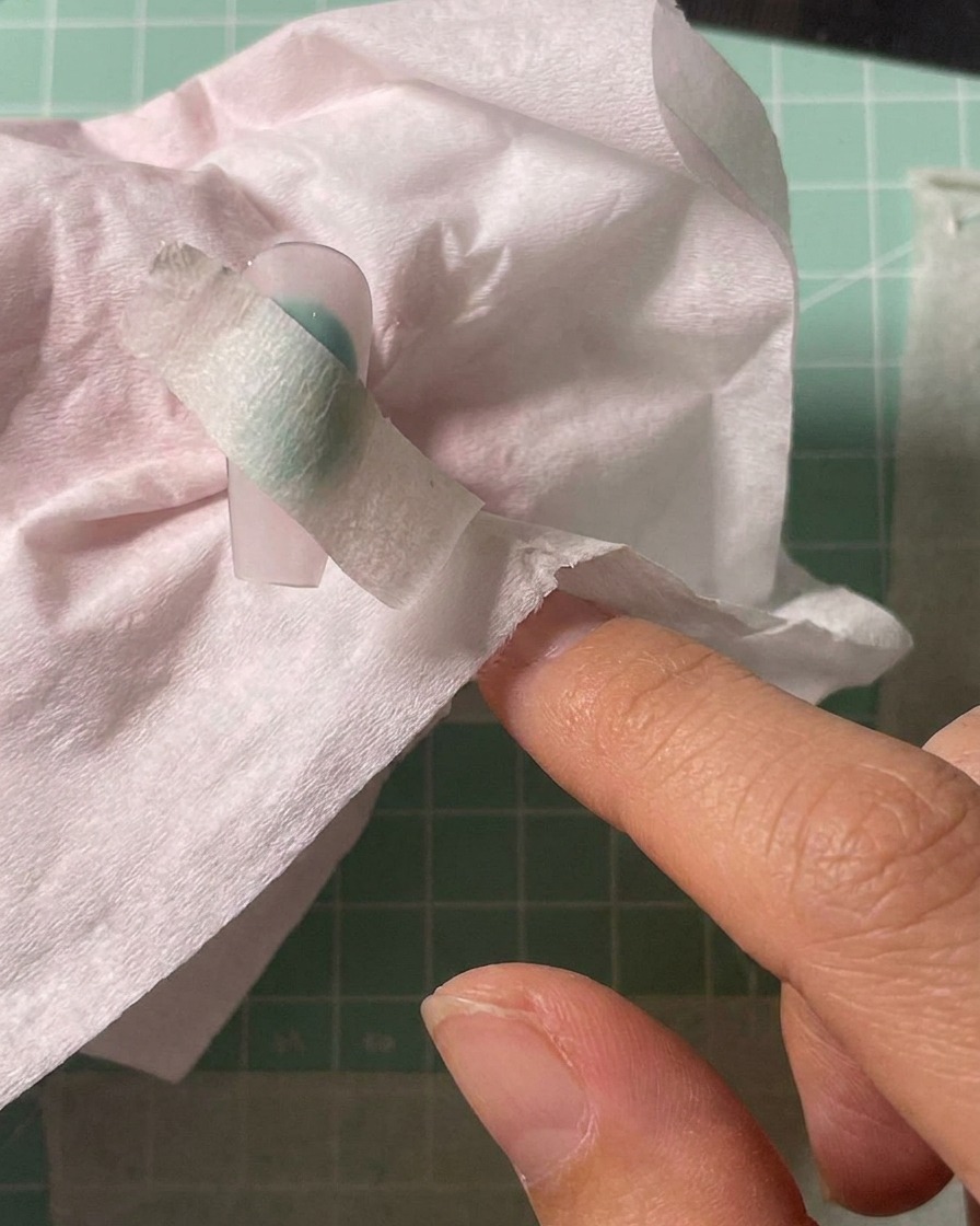 Utilisation dun aérographe pour pulvériser du pigment blanc sur une zone délimitée de longle.