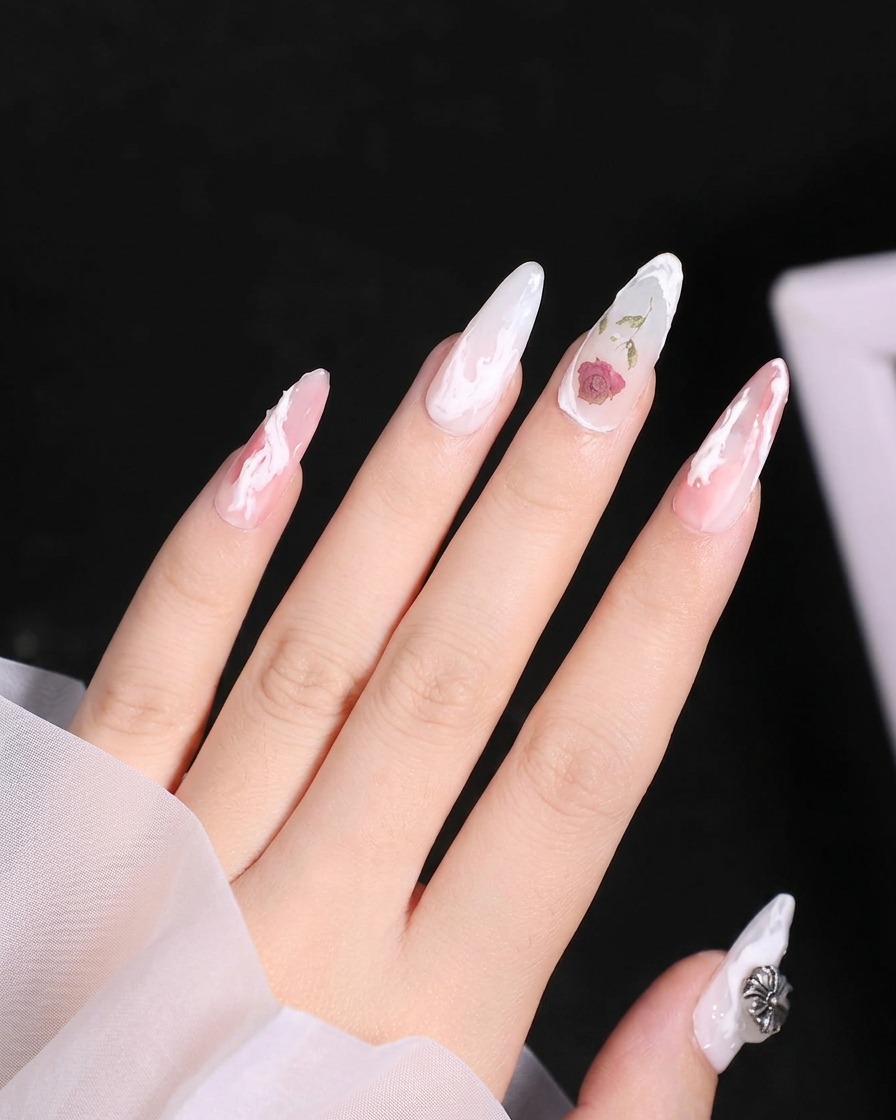 Une vue rapprochée montrant les pétales inférieurs ajoutés au design de rose en gel blanc sur longle.