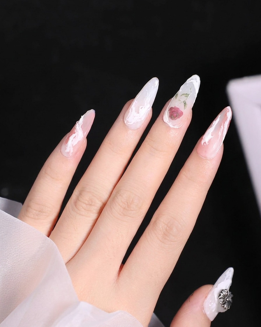 Un petit pinceau de détail appliquant une teinte de gel rouge transparente sur la section supérieure dune rose soulignée de blanc.