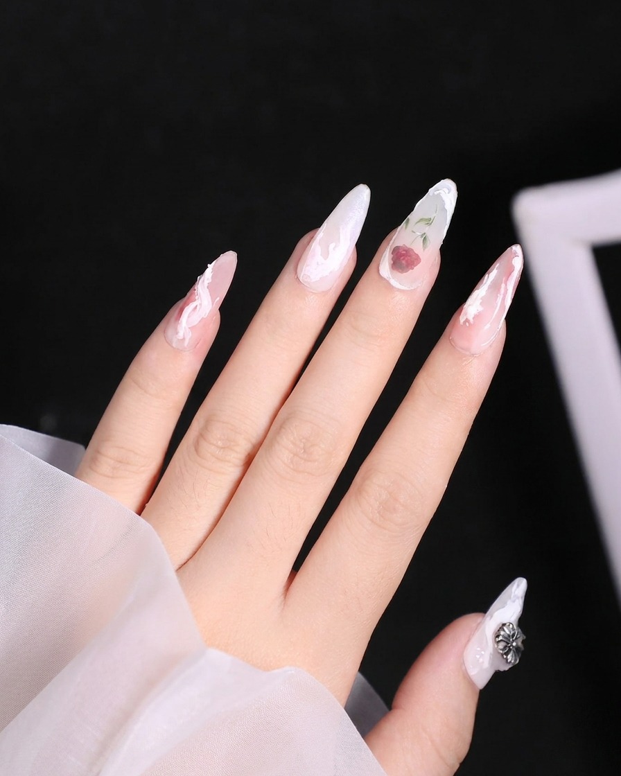 Un pinceau estompant la couleur rouge à travers les pétales inférieurs dun design de rose délicat sur un ongle.