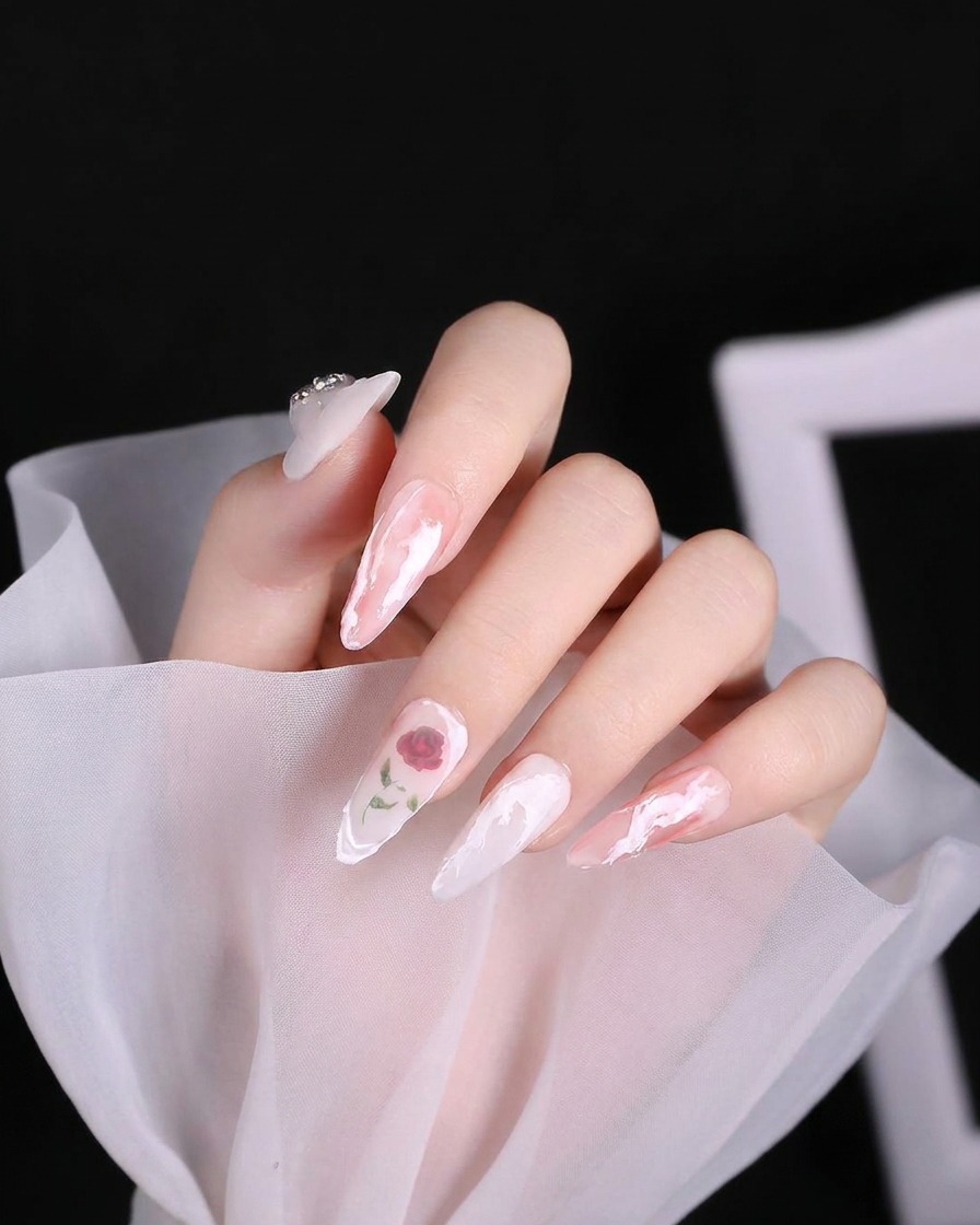 Un pinceau de nail art appliquant une volute de gel blanc texturé et épais sur la zone de la cuticule dun ongle.